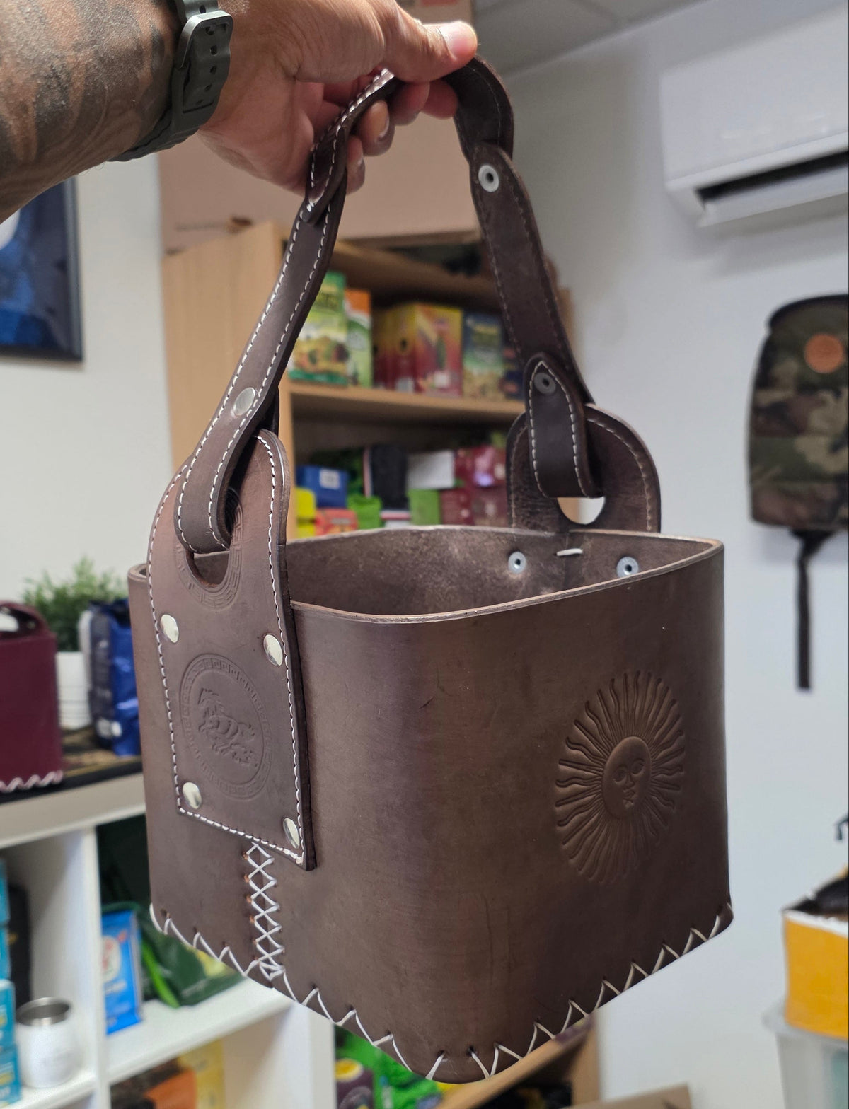 Canasta Matera Premium en cuir marron tabac, édition Sol de Mayo : vue de côté avec l'anse et le soleil repoussé