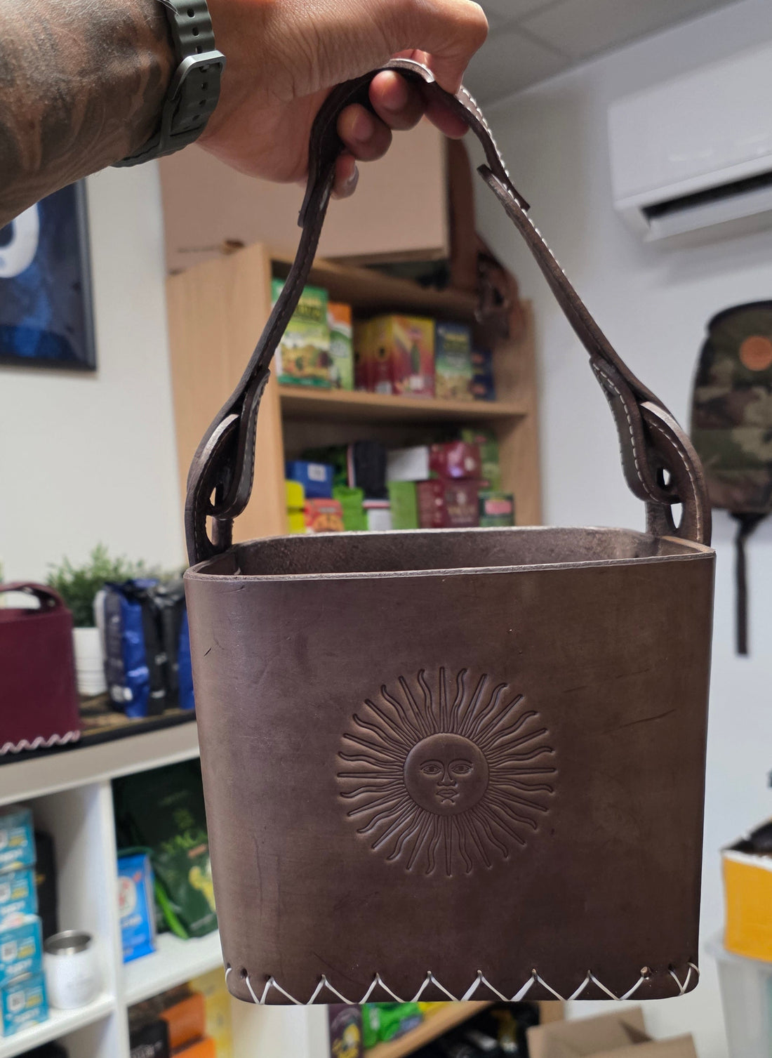 Canasta Matera Premium en cuir marron tabac, édition Sol de Mayo : vue de côté avec l'anse et le soleil repoussé