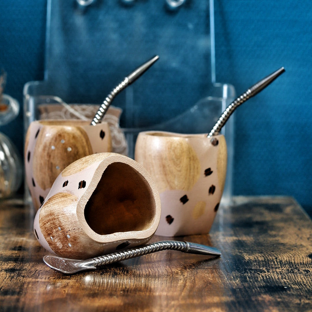 Maté Ranchero en bois d'Algarrobo couché, montrant les détails peints à la main et les clous de la Croix du Sud.