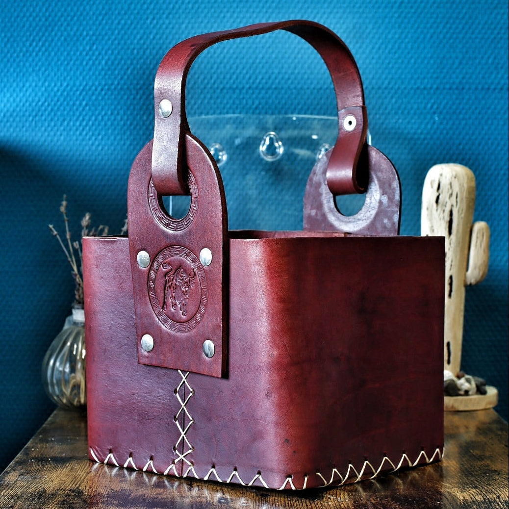 Matera artisanale en cuir bordeaux, anse à rivets et logo taureau en relief.