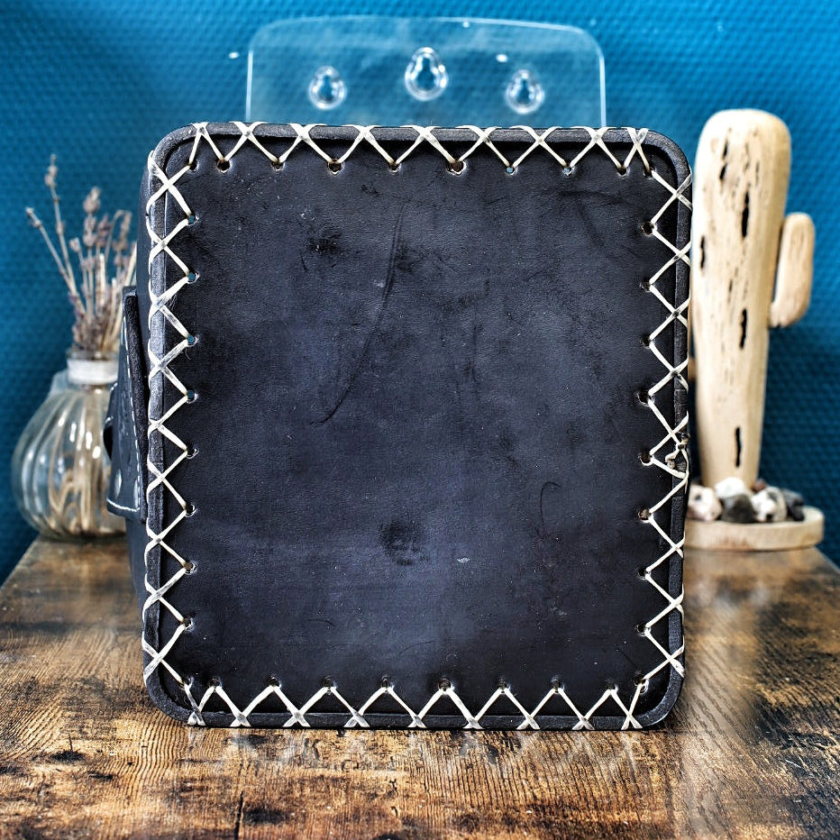 Dos de matera en cuir noir, montrant le travail artisanal des coutures blanches.