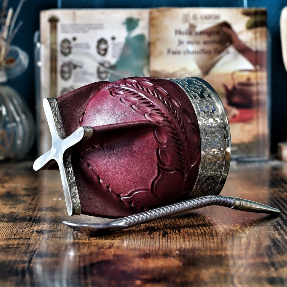 Gros plan sur la base ciselée en maillechort (alpaca) et le corps en cuir bordeaux labré du maté Imperial. On y voit clairement les détails du travail du cuir et les motifs Pampa sur la bande de cuir, contrastant avec la virole lisse en maillechort en haut.