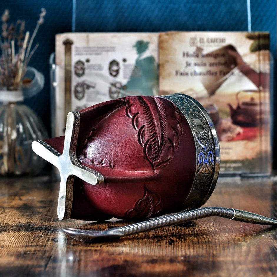 Gros plan sur la base ciselée en maillechort et le cuir bordeaux labré, montrant les détails du fleje abstrait contrastant avec la virole lisse.