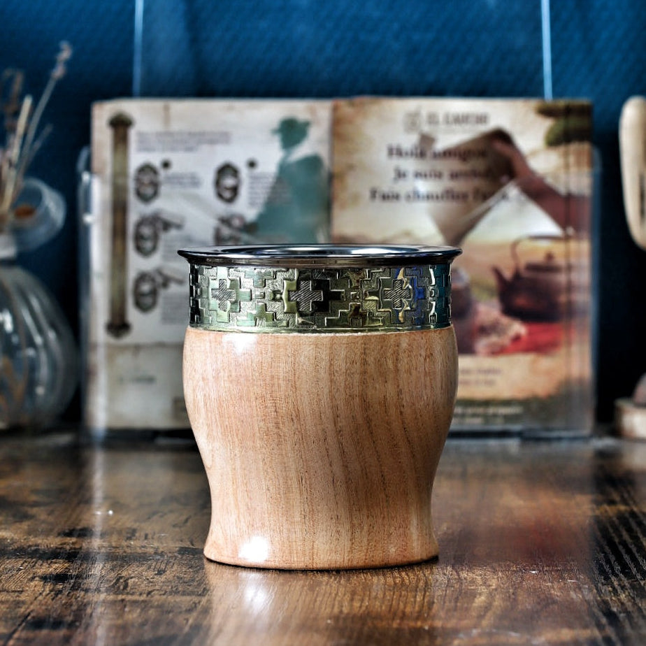 Maté de forme Impérial tonneau (barril) en bois massif de caroubier (algarrobo), doté d'une virole lisse en alpaga et d'un "fleje" (bande métallique) ciselé avec un motif traditionnel géométrique Guarda Pampa, symbole de la culture argentine.