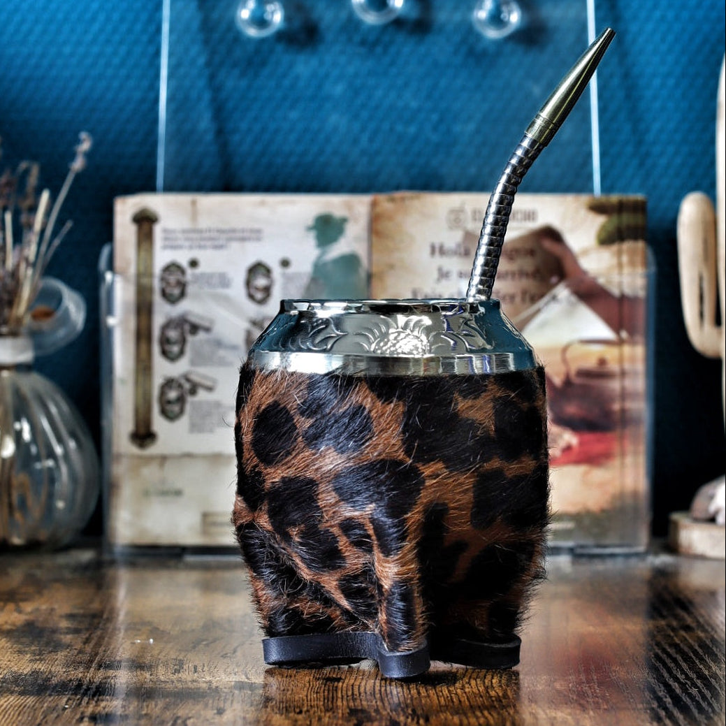 Maté de forme Torpedo artisanal en calebasse naturelle avec un double revêtement en cuir et motif Animal Print, surmonté d'une virole finement ciselée, présenté avec sa bombilla.