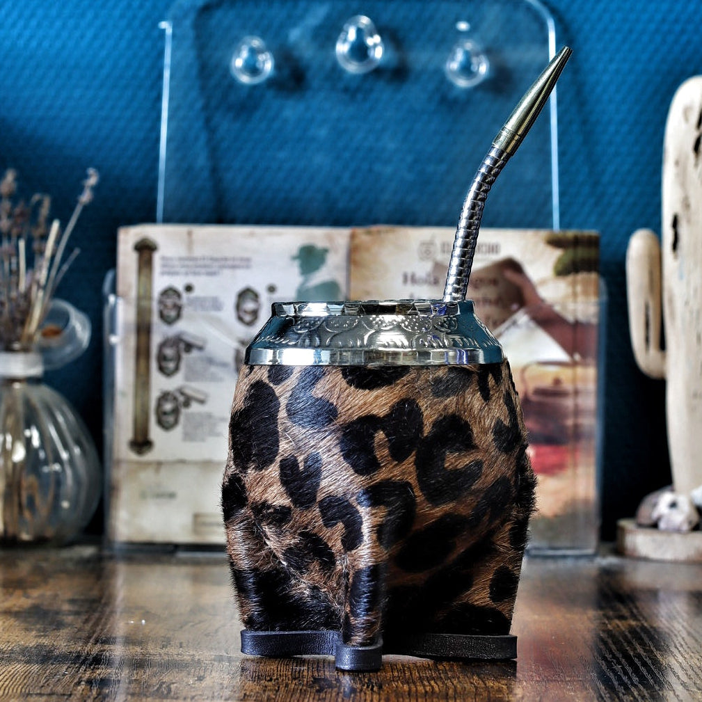 Photo d'une pièce unique de maté Torpedo Animal Print avec une virole finement ciselée à la main et une base en cuir renforcée, style artisanal argentin, présenté avec une bombilla en acier inoxydable.