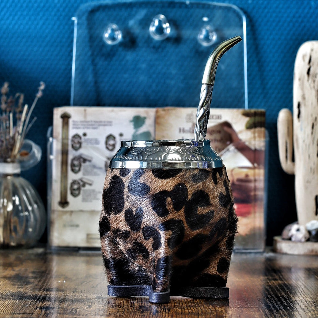 Photo d'une pièce unique de maté Torpedo Animal Print avec une virole finement ciselée à la main et une base en cuir renforcée, style artisanal argentin, présenté avec une bombilla en acier inoxydable.