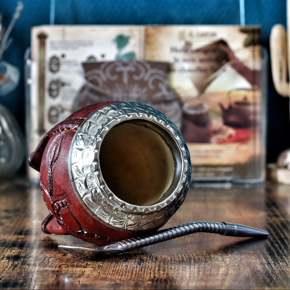 Gros plan sur l'art du cuir labrado : détails de feuilles sculptées à la main sur le cuir borravino et virole en Alpaca.