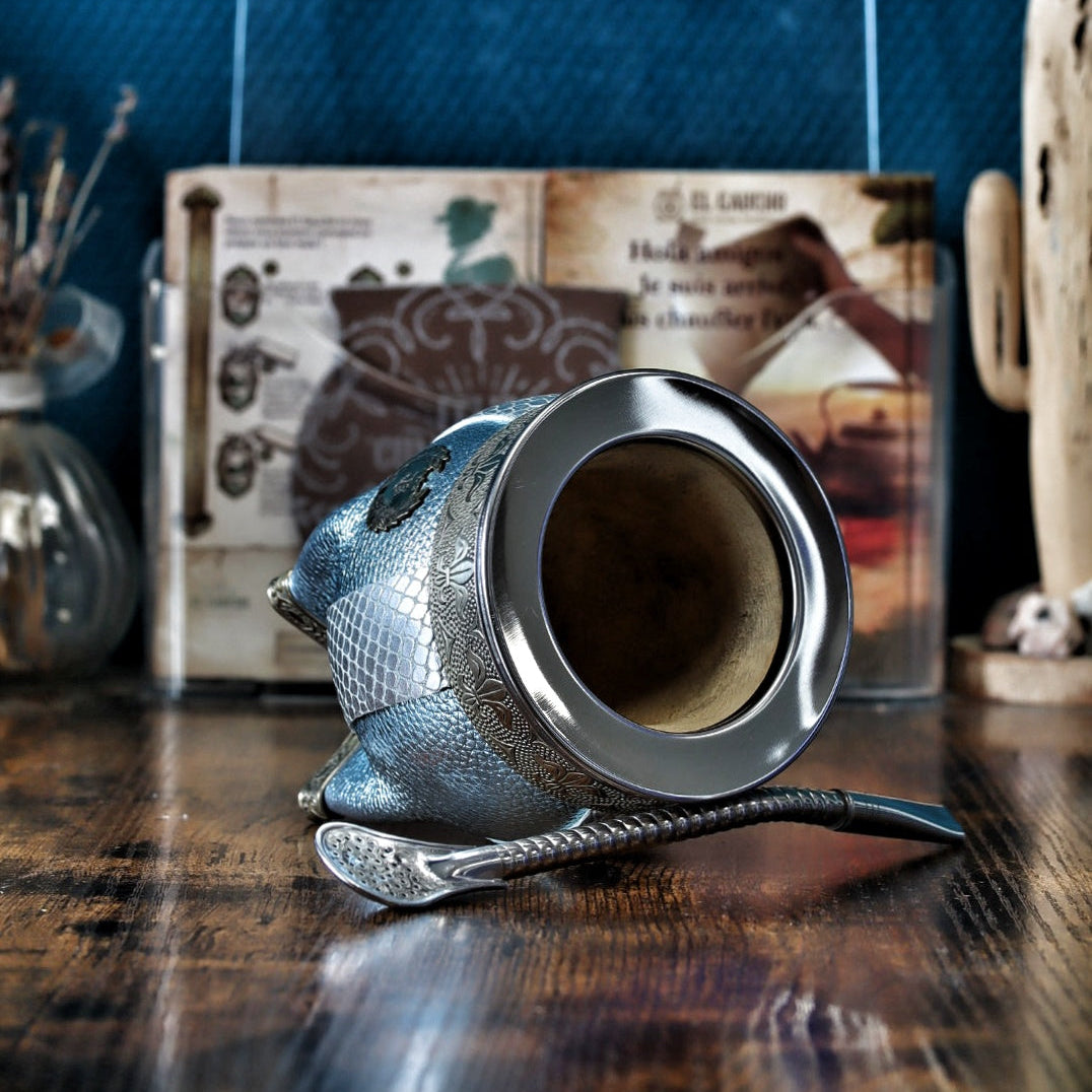 Gros plan sur la virole lisse en Alpaca et le ruban orné de Fleurs de Lys sur le cuir texturé bleu céleste et blanc.