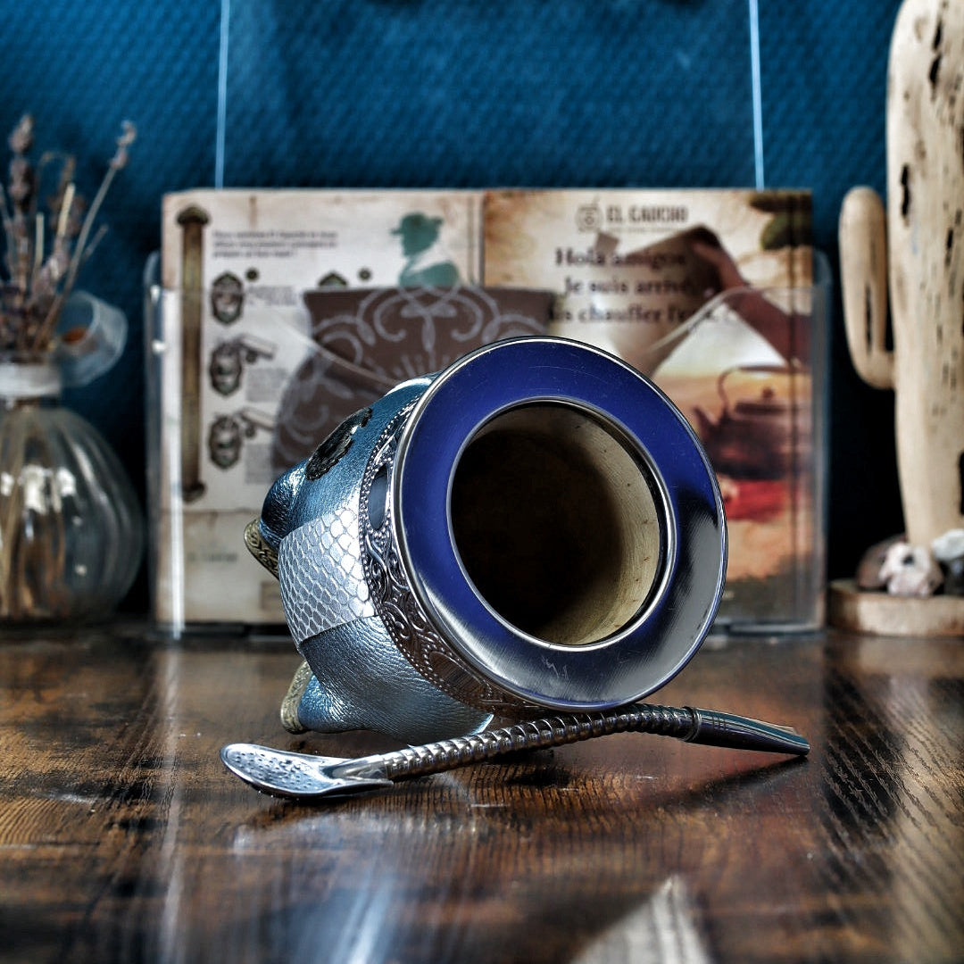 Gros plan sur la virole lisse en Alpaca et le ruban aux motifs abstraits modernes sur le cuir texturé bleu céleste.