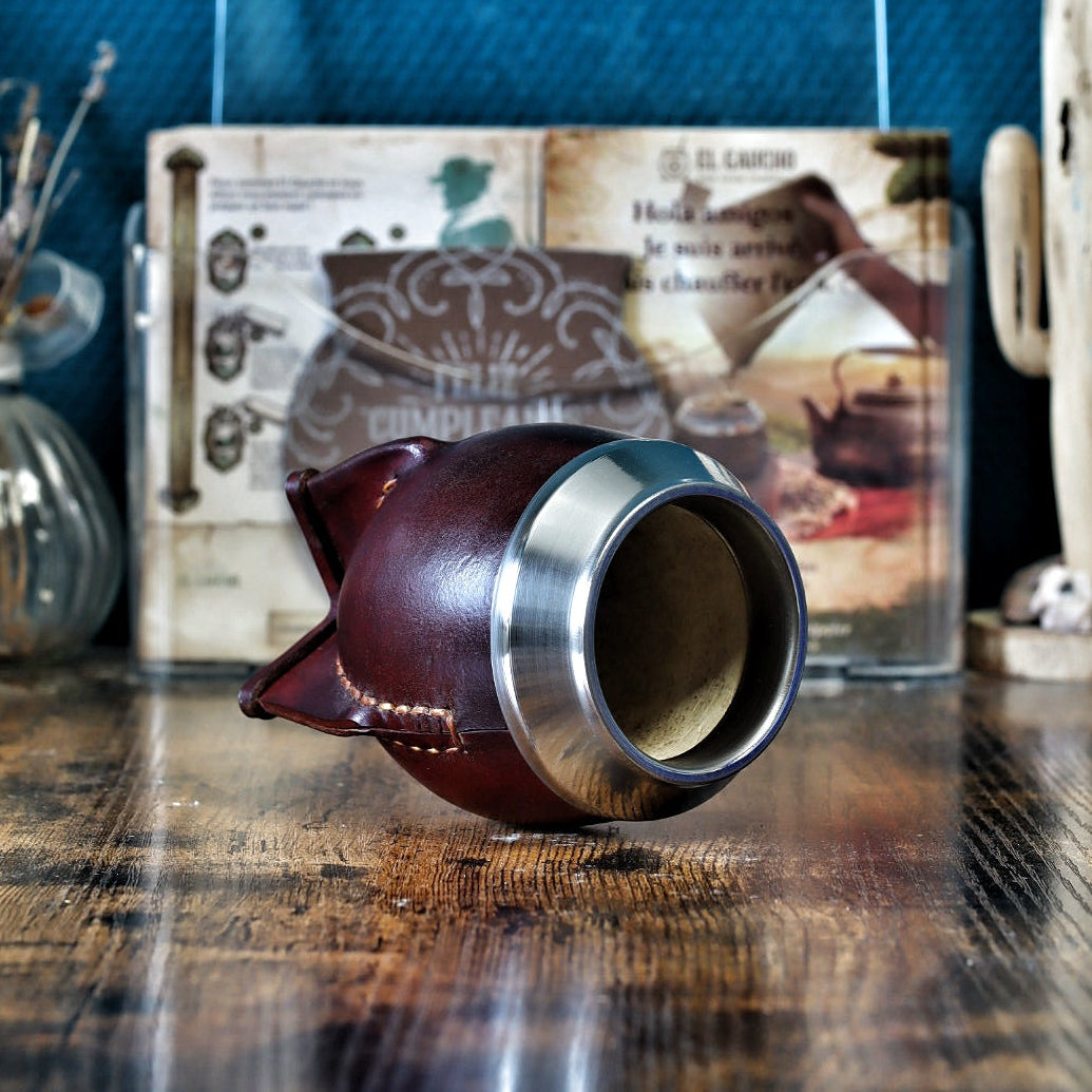 Maté Torpedo classique uruguayen en cuir lisse borravino avec virole en acier inoxydable posé verticalement.