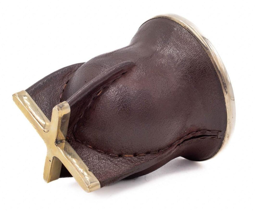 Profil couché : cuir brun cousu, base en croix, fond visible.