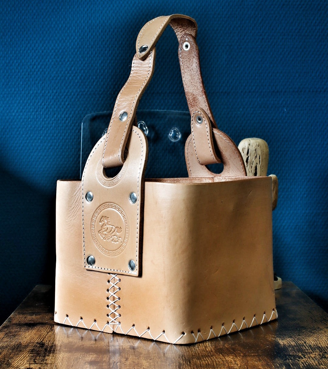 Canasta Matera Premium en cuir naturel beige, cousue main au point sellier, anses rivetées et médaillon estampé.