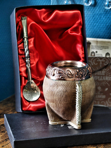 Maté Torpedo « Orfebre » N°5 : calebasse en cuir cru cousue au tiento et virole en cuivre repoussé, devant son coffret avec le bombillón