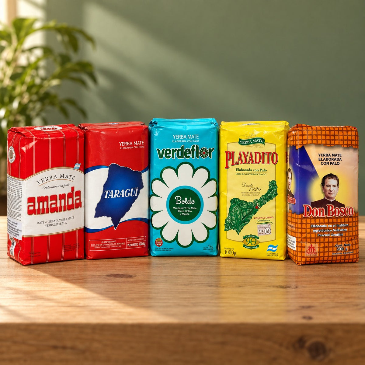 Pack Argentine Grand Format : 5 paquets de yerba maté de 1 kg (Amanda, Taragüi, Verdeflor Boldo, Playadito, Don Bosco) sur une table en bois