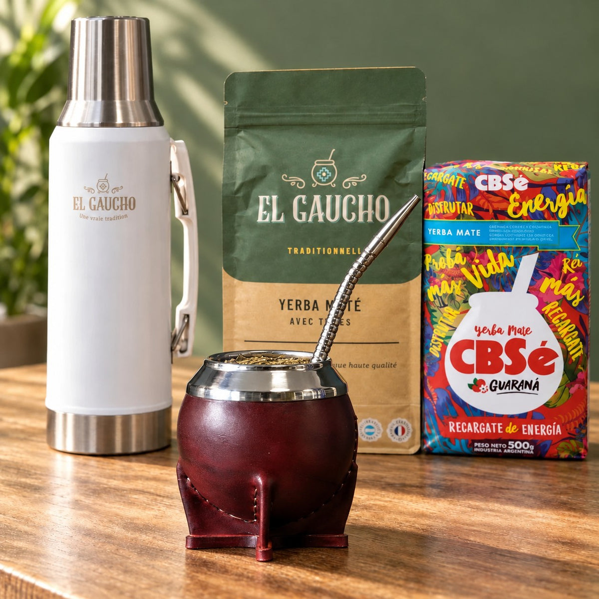 Pack Gaucho Classique Premium Thermo : maté Torpedo Deluxe cuir bordeaux, thermos blanc 1,2 L, yerba El Gaucho et CBSé sur une table en bois