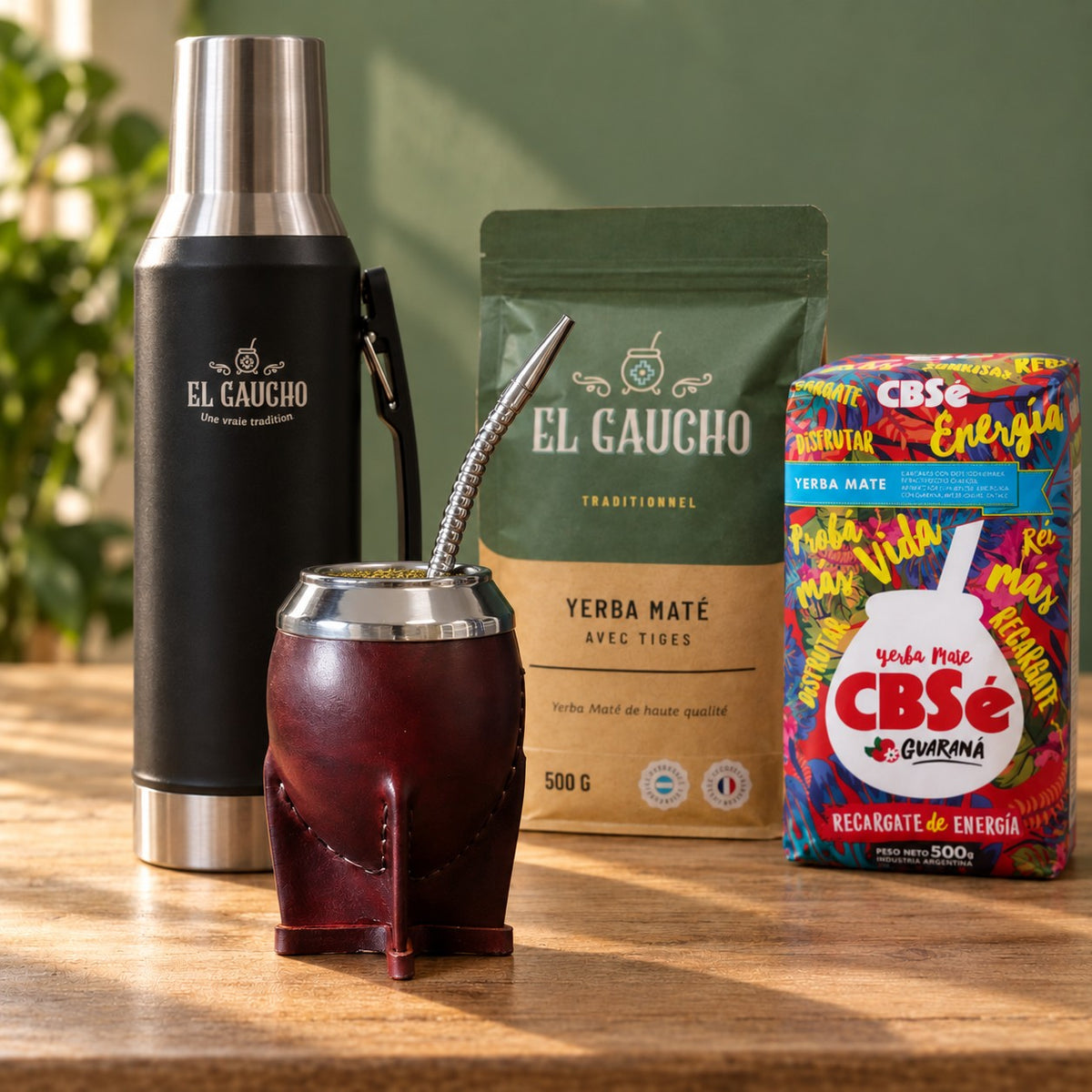Pack Gaucho Classique Premium Thermo : maté Torpedo Deluxe cuir bordeaux, thermos noir 1,2 L et deux paquets de yerba sur une table en bois
