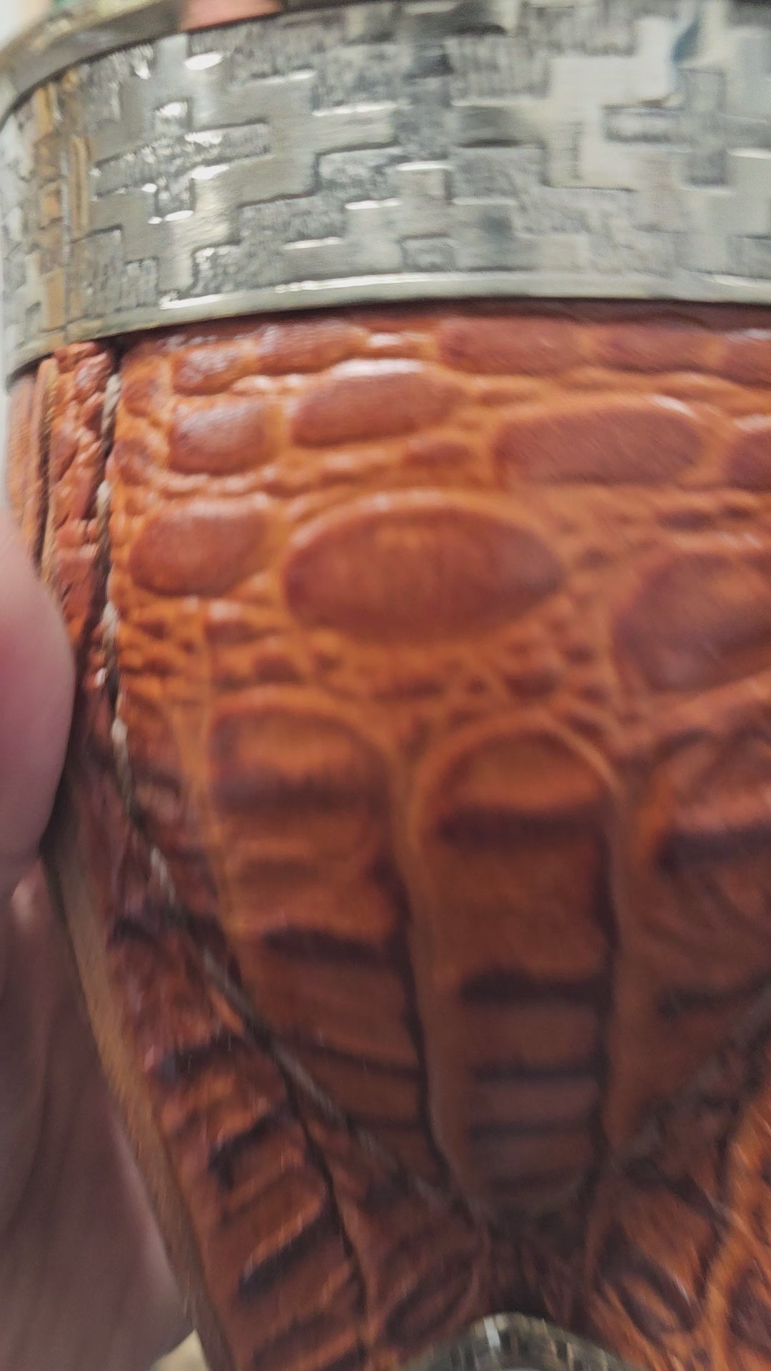 (Vidéo) Gros plan sur la texture cuir crocodile et le détail de la virole alpaca/bronze.