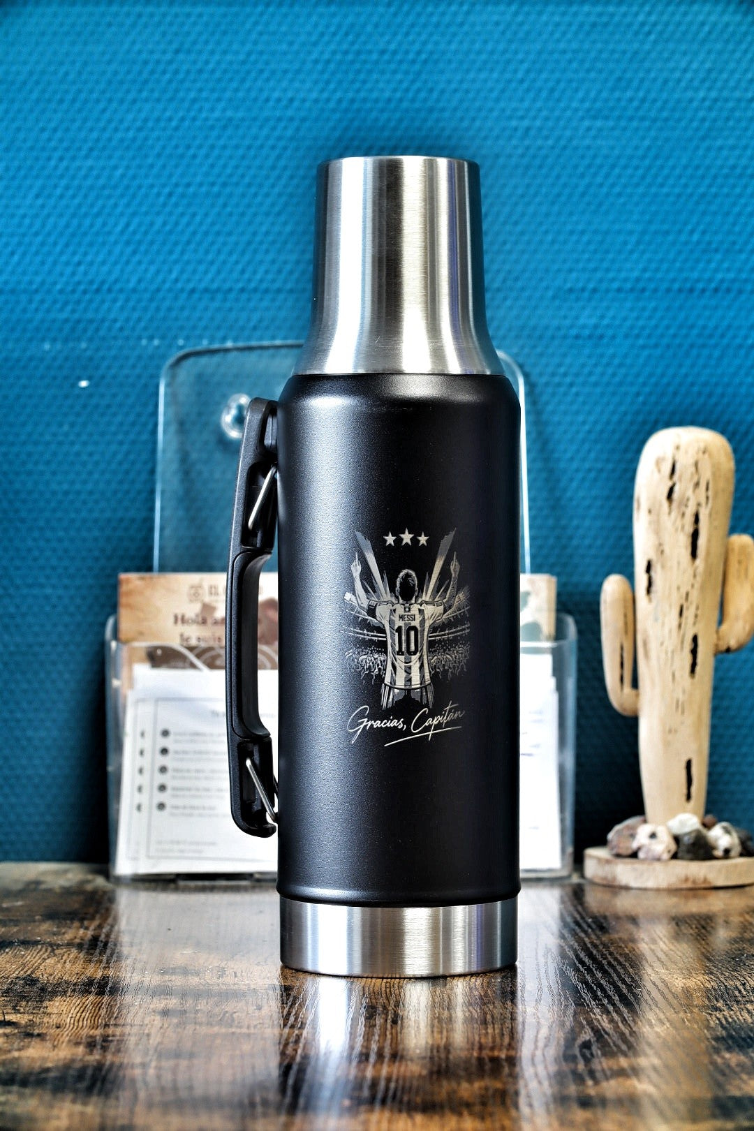 Thermo Gaucho noir 1,2 L gravé « Gracias, Capitán » posé sur une table en bois, le 10 de dos sous trois étoiles